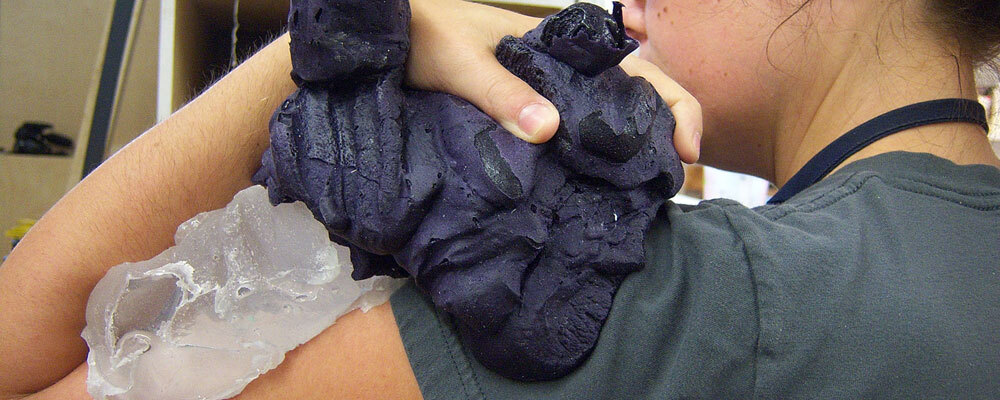 Photo de l'artiste réalisant un moulage de son épaule